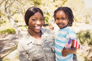 Female soldier smiling while holding her daughter